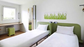 A hotel room with two single beds, a small stool, a window, and a wall-mounted digital clock. - ibis budget Blois Centre (Blois)