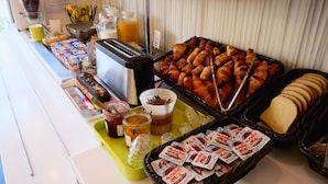 A breakfast buffet with various food items and condiments. - ibis budget Blois Centre (Blois)