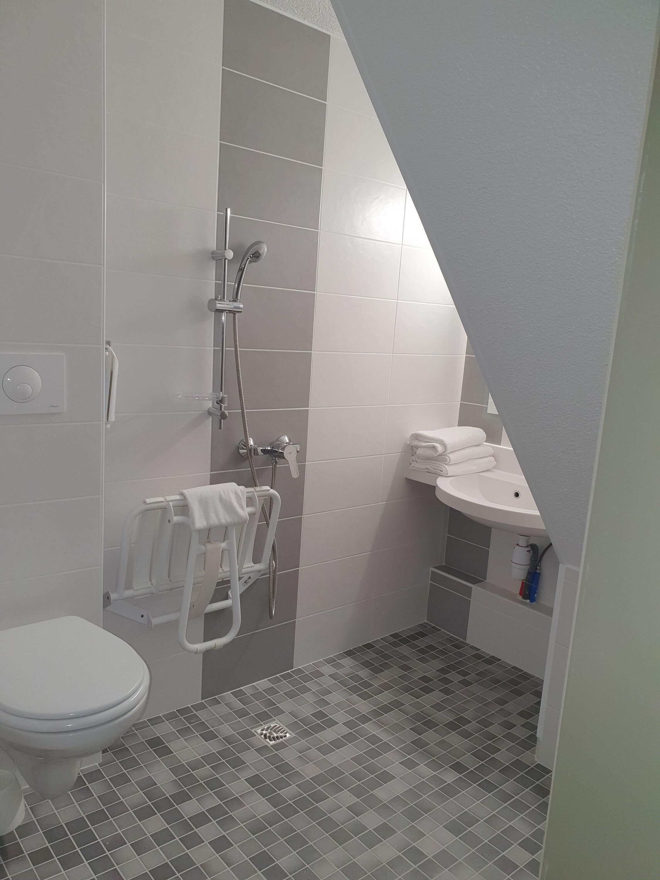 Ein kleines Badezimmer mit Toilette, Dusche und Waschbecken.
