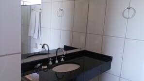 A bathroom with a black sink, two faucets, a mirror, and a towel ring on the wall. - CANTO VERDE HOTEL PARA RANCHARIA PARK HOTEL (Rancharia)