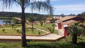 Un resort con piscina, palmeras y vistas a un lago.