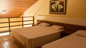Camera da letto con due letti, soffitto in legno e un quadro con fiori al muro.