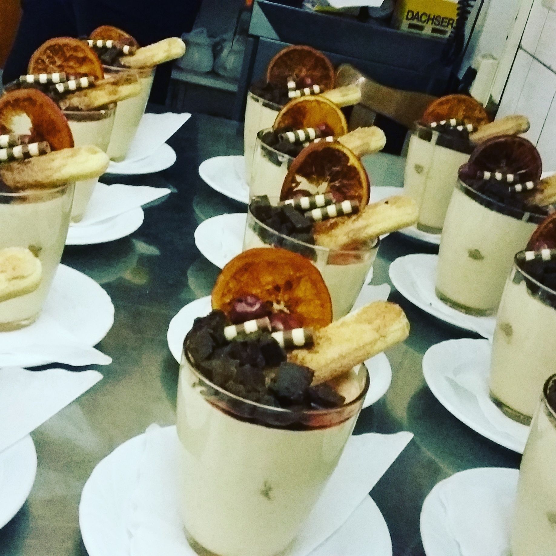 Dessert cups with fruit and chocolate pieces on a table.
