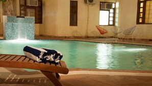 Un área de piscina con un banco de madera y una toalla.