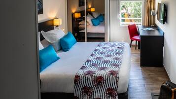 Una habitación de hotel con cama, escritorio, silla y armario.