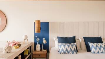 A bedroom with a wooden headboard, a bedside table with a lamp, a hanging light fixture, and a bookshelf.