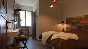 Un dormitorio con una cama, un escritorio con una silla y una ventana.