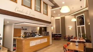 Un restaurante con mostrador central, varias mesas y sillas.