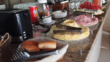 Disposição de buffet com diversos alimentos e utensílios.