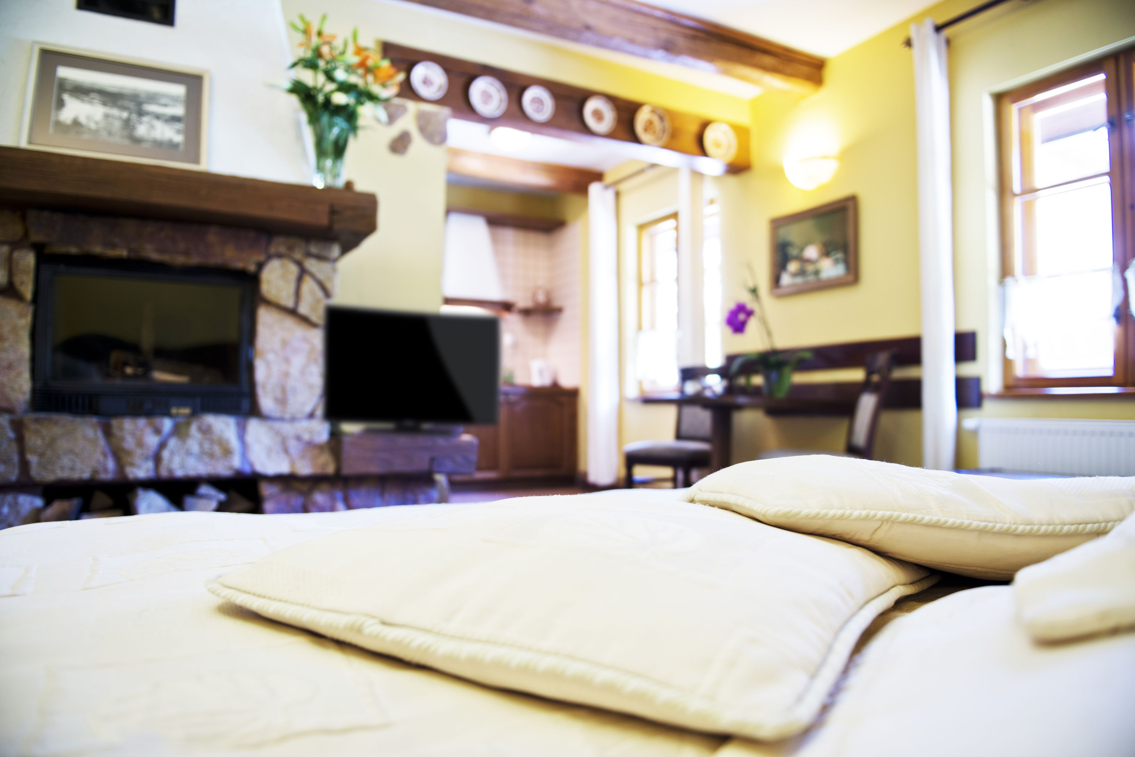 Una camera d'albergo con un letto, una televisione, un camino e un'area pranzo sullo sfondo.