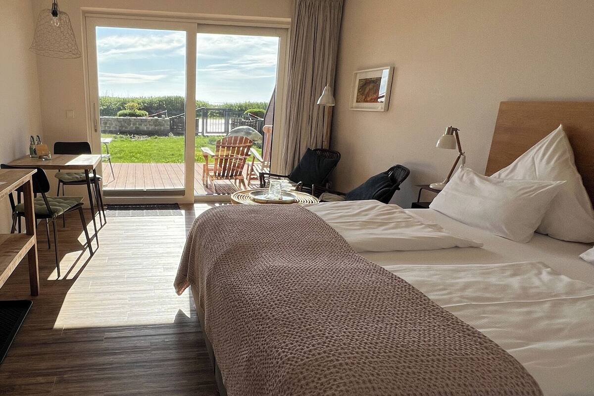 Een hotelkamer met een groot bed, een bureau en uitzicht op de omgeving.