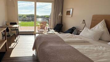 Habitación de hotel con una cama grande, un escritorio y vistas al exterior.
