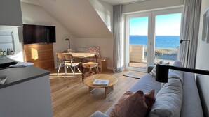 Departamento Deluxe, 2 habitaciones, sauna, vista al mar (Dünenhaus) | Área de sala de estar | Televisión de pantalla plana 