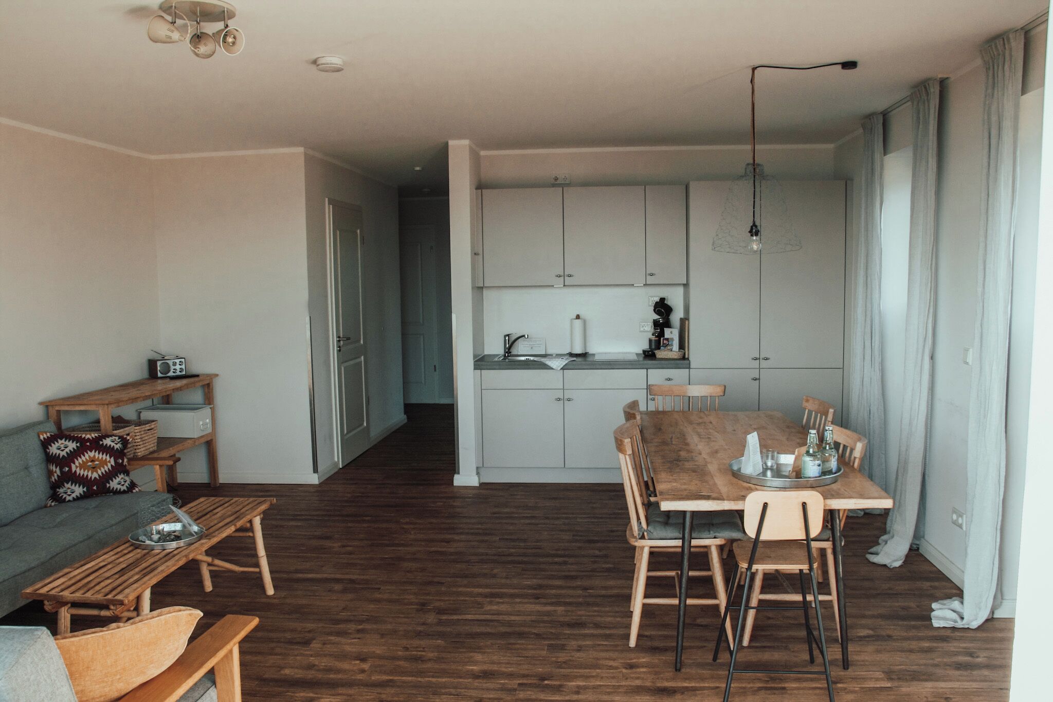 Un apartamento moderno con sala de estar, una mesa de comedor y una kitchenette.