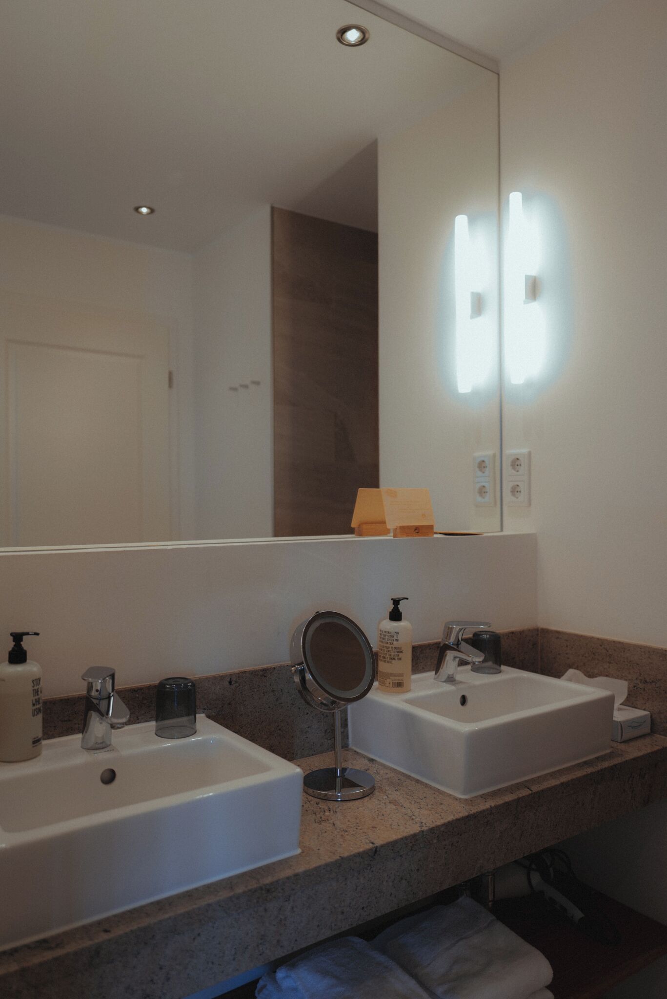 A bathroom with two sinks, a mirror, and a towel rack.