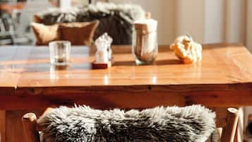 A wooden table with various items including a glass, a ceramic pot, and a decorative object.