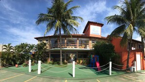A two-story building with a stone facade, a balcony, and a sign reading "Porto Canal Pousada". - Pousada Porto Canal (Cabo Frio)