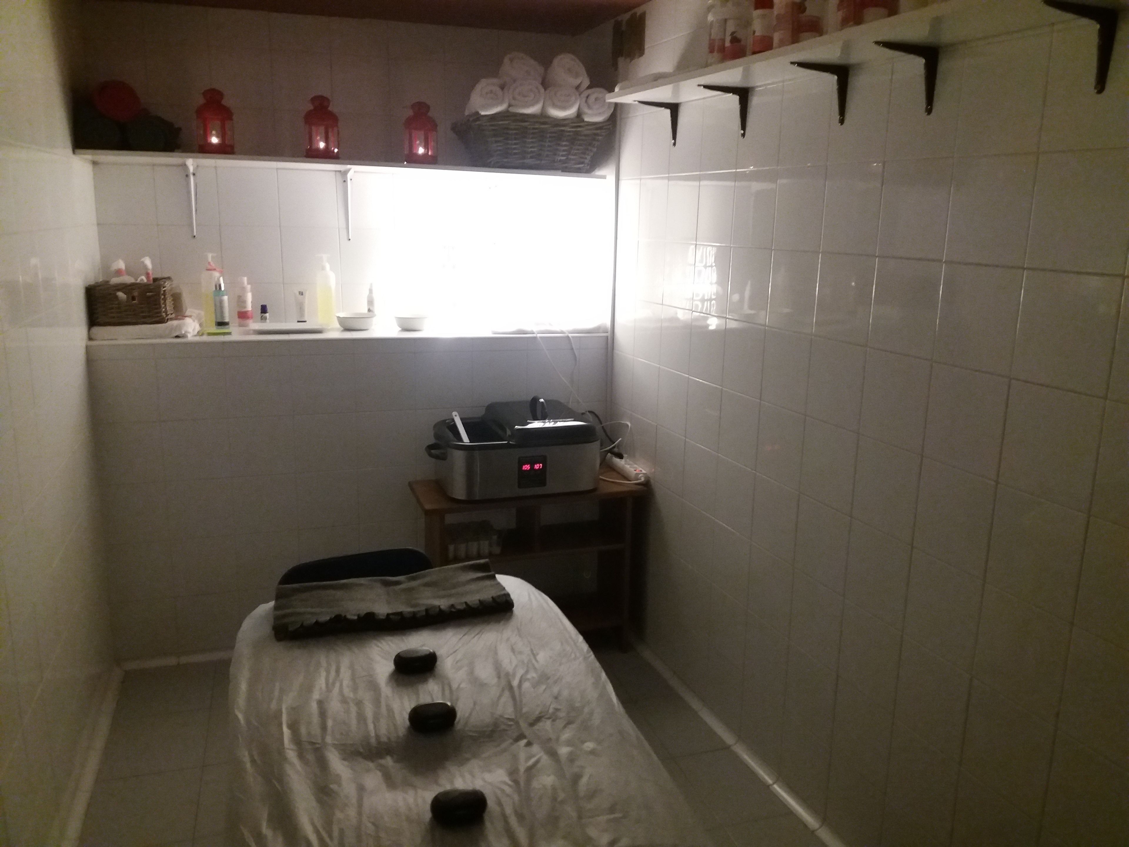 A small room with a bed, a window, and a shelf with toiletries.