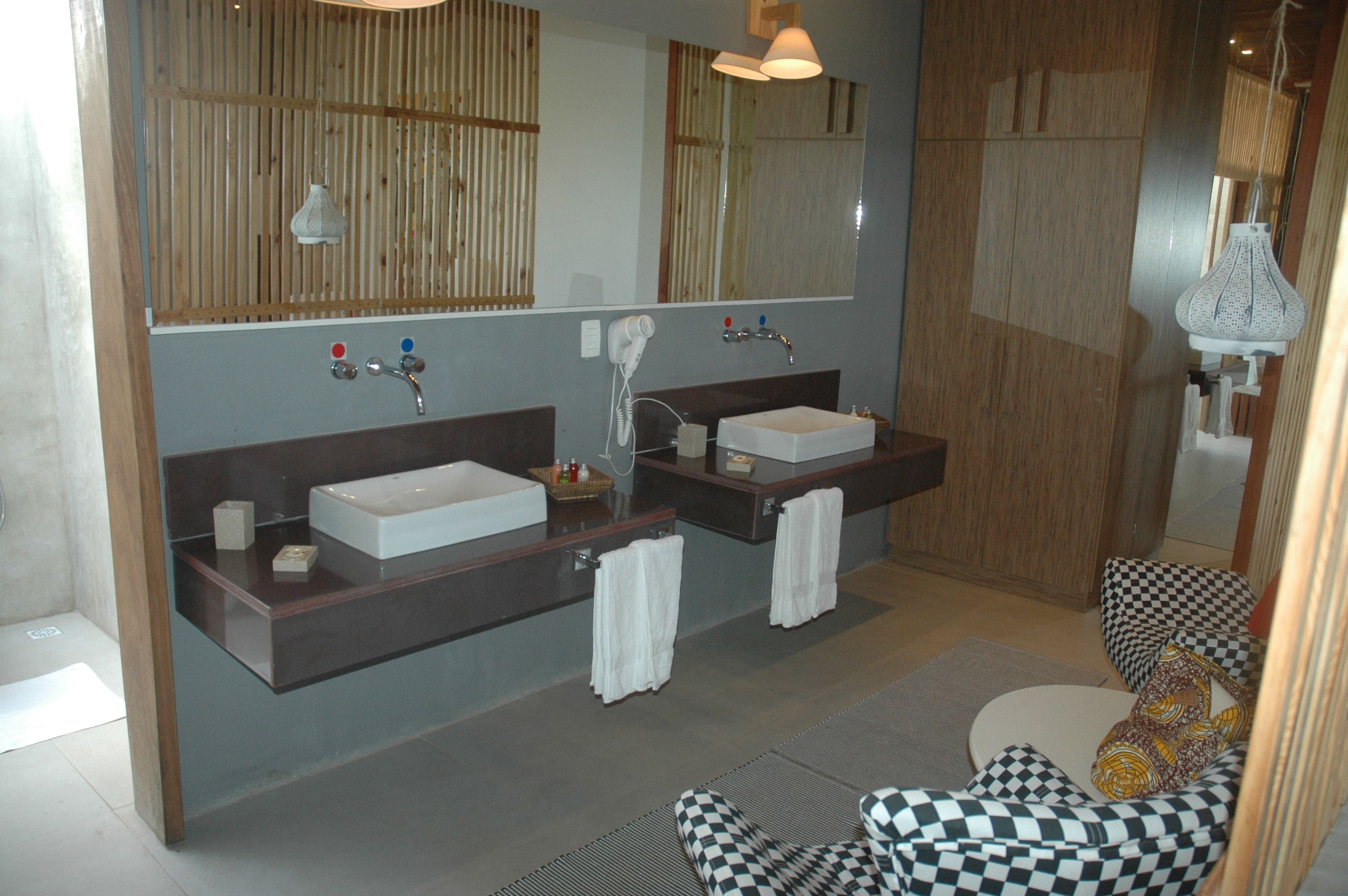Un baño moderno con dos lavamanos, un espejo grande y un perchero para toallas.