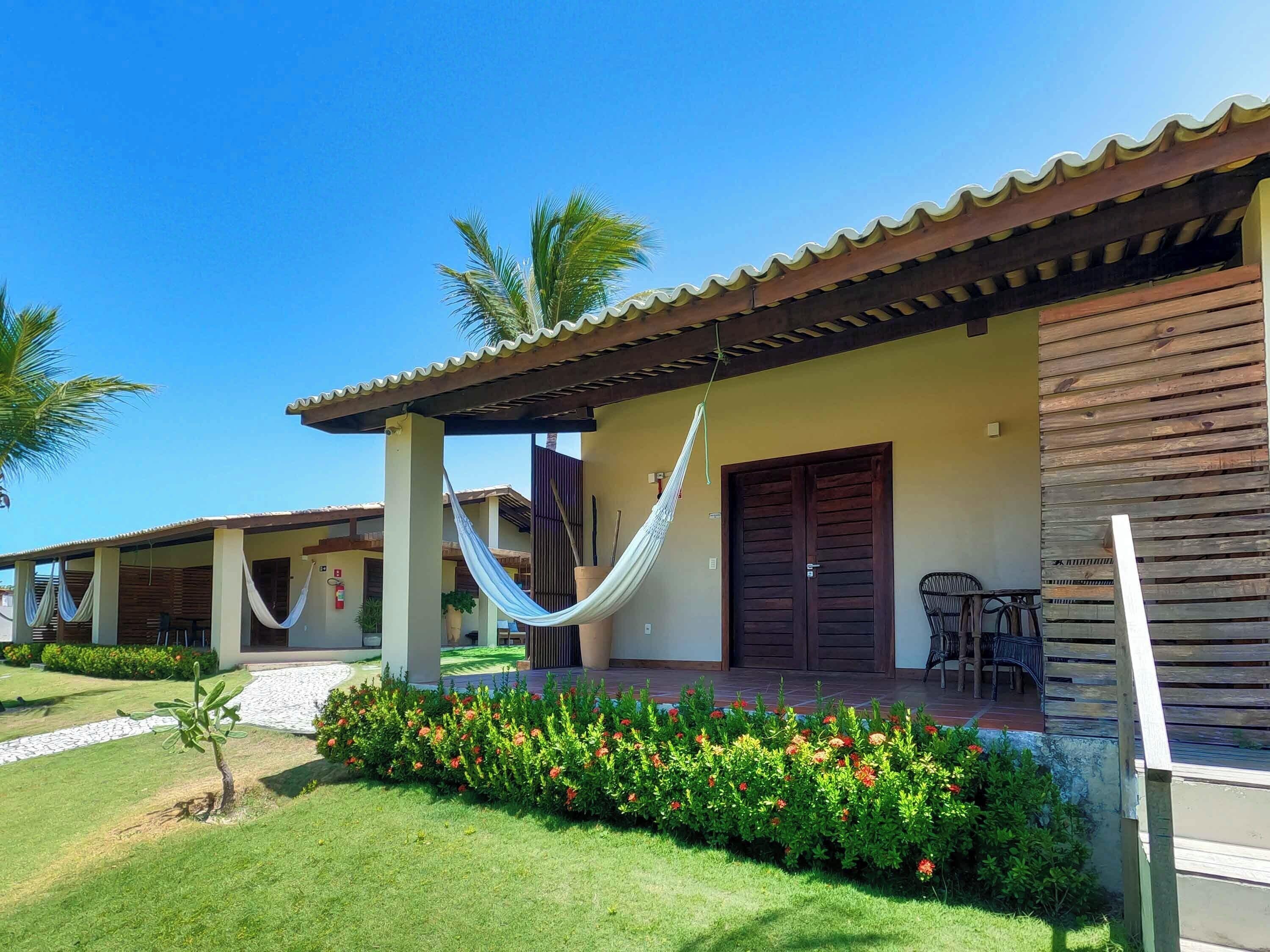 A building with a covered porch, a hammock, and a door.