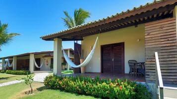 A building with a covered porch, a hammock, and a door.