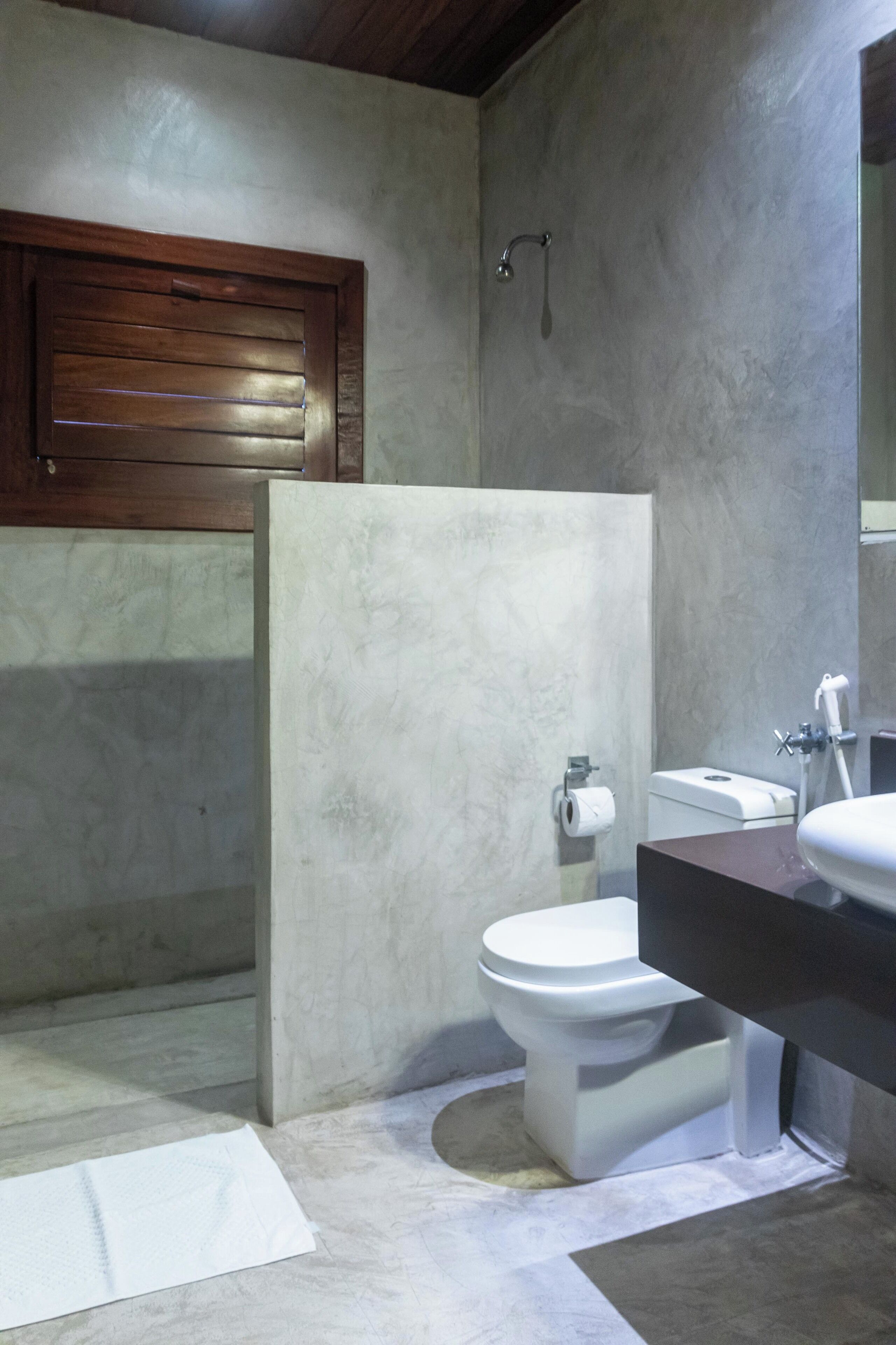 Un baño moderno con inodoro, lavamanos y ducha.
