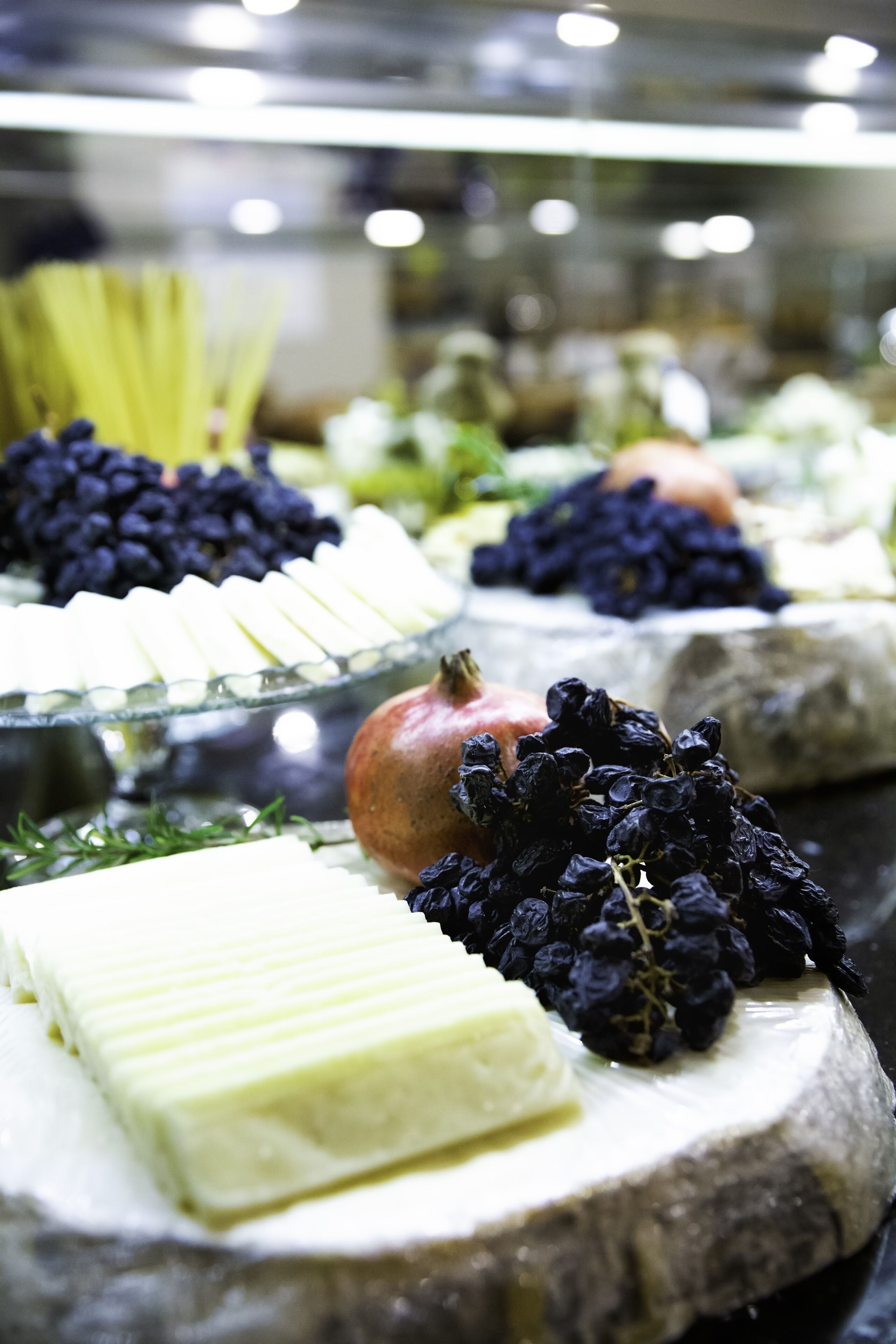A cheese board with various cheeses and fruits.