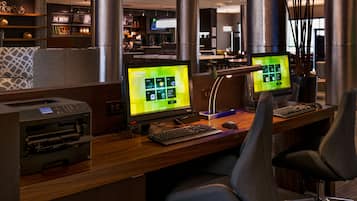 Un espacio de oficina moderno con dos puestos de trabajo, cada uno con un monitor grande que muestra una interfaz digital.