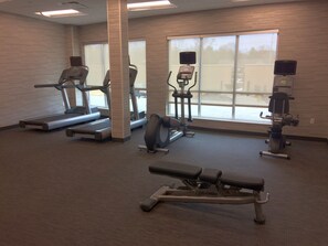 A gym with treadmills, elliptical machines, and a bench. - Courtyard by Marriott Somerset (Somerset)
