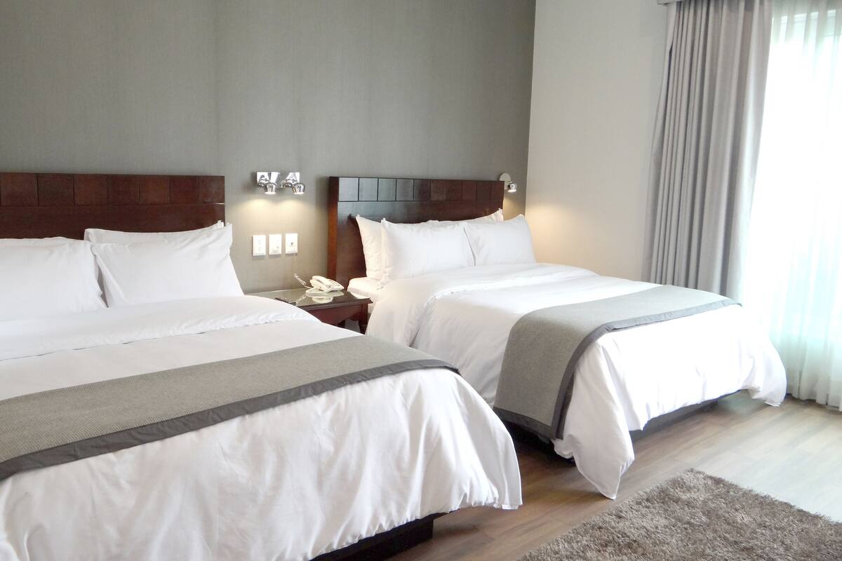 Habitación Deluxe, 2 camas de matrimonio | Caja fuerte, escritorio, tabla de planchar con plancha y wifi gratis