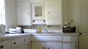 A kitchen with white cabinets, a microwave, and a sink.