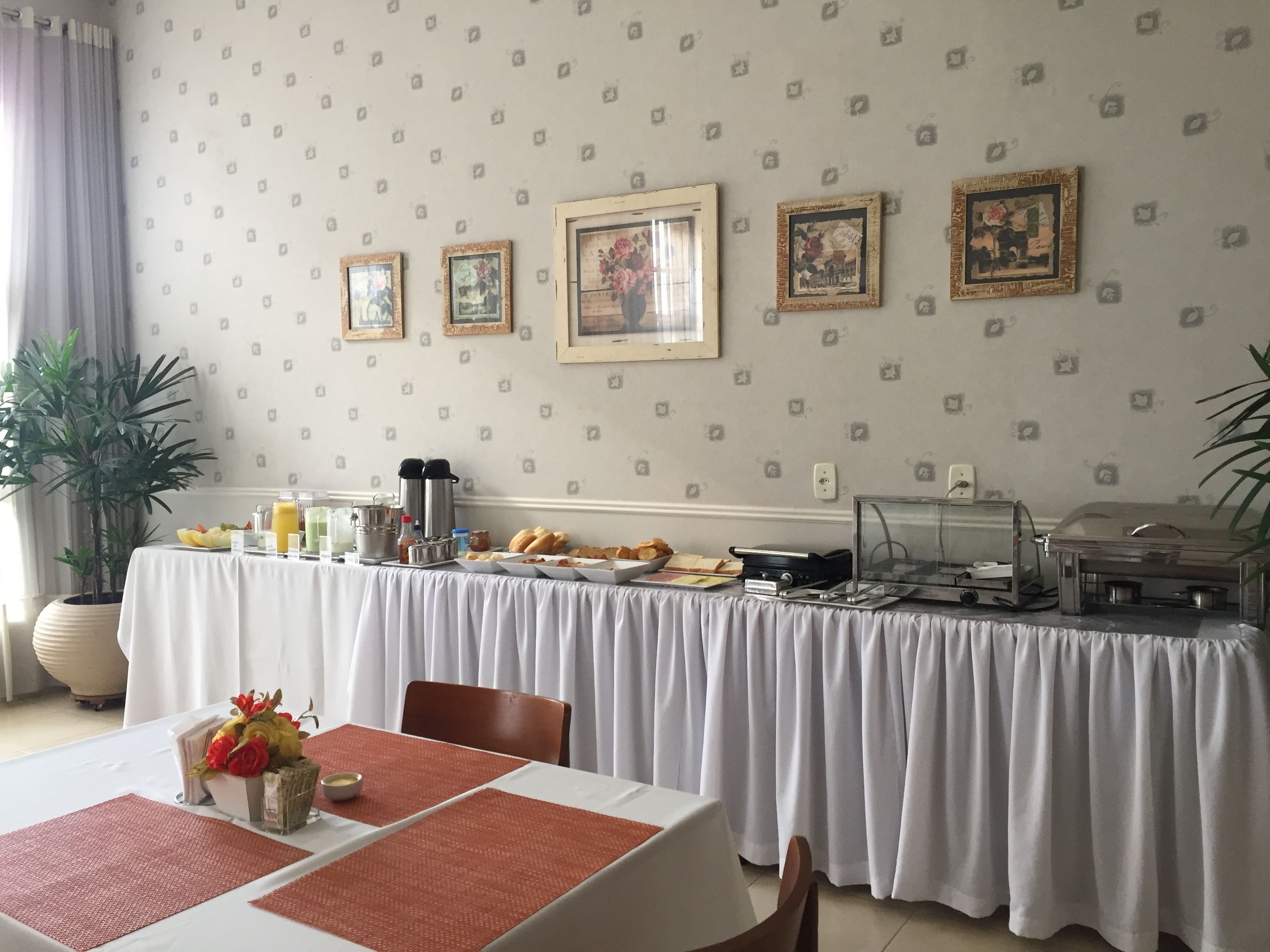 Un buffet de petit-déjeuner comprenant une table, des chaises et une variété d’aliments.