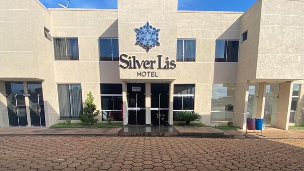 Fachada del Hotel Silver Lis con pavimento de baldosas hexagonales al frente.