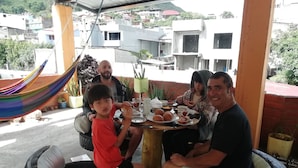 Uma família jantando à mesa com vista para a cidade.