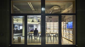 Un espace intérieur comprenant un comptoir d’accueil, un coin salon et des étagères où sont exposés divers objets.