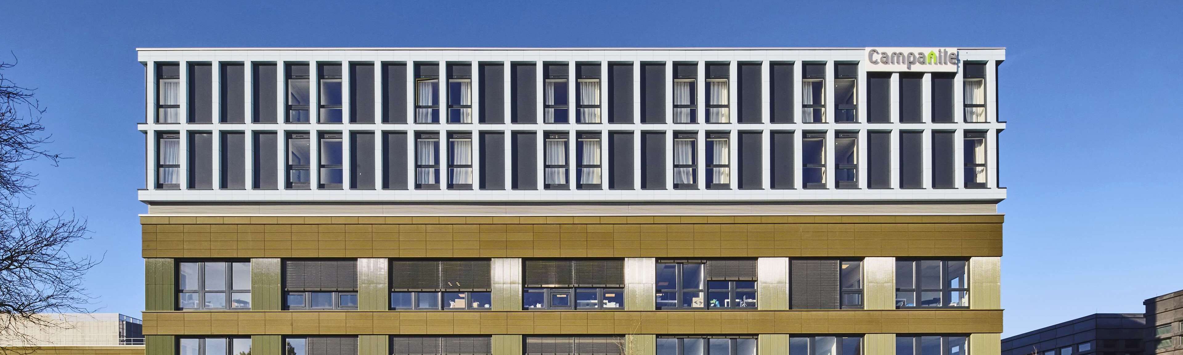 A modern building with a flat roof, large windows, and a sign that reads "campanile".