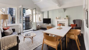 A modern living room with a dining area, large windows, and a fireplace. - Native Fenchurch  (London)