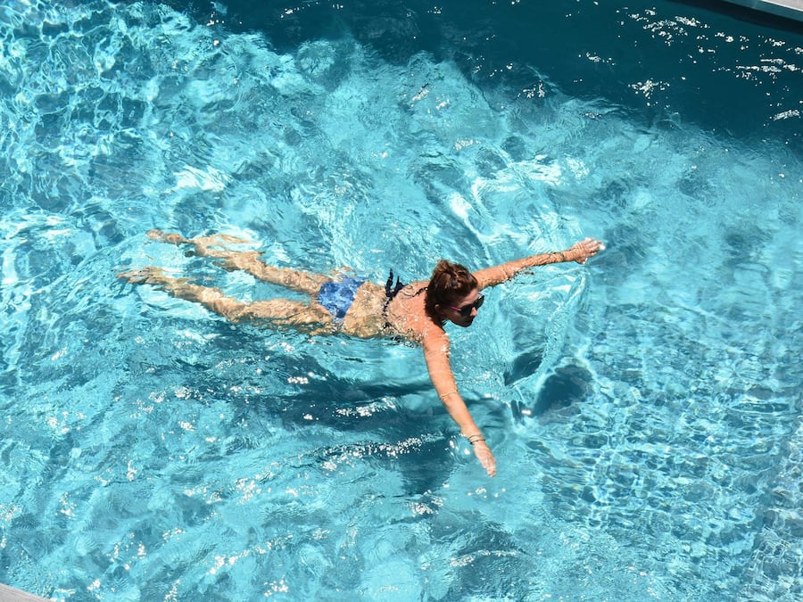 Una piscina al aire libre, sillones reclinables de piscina