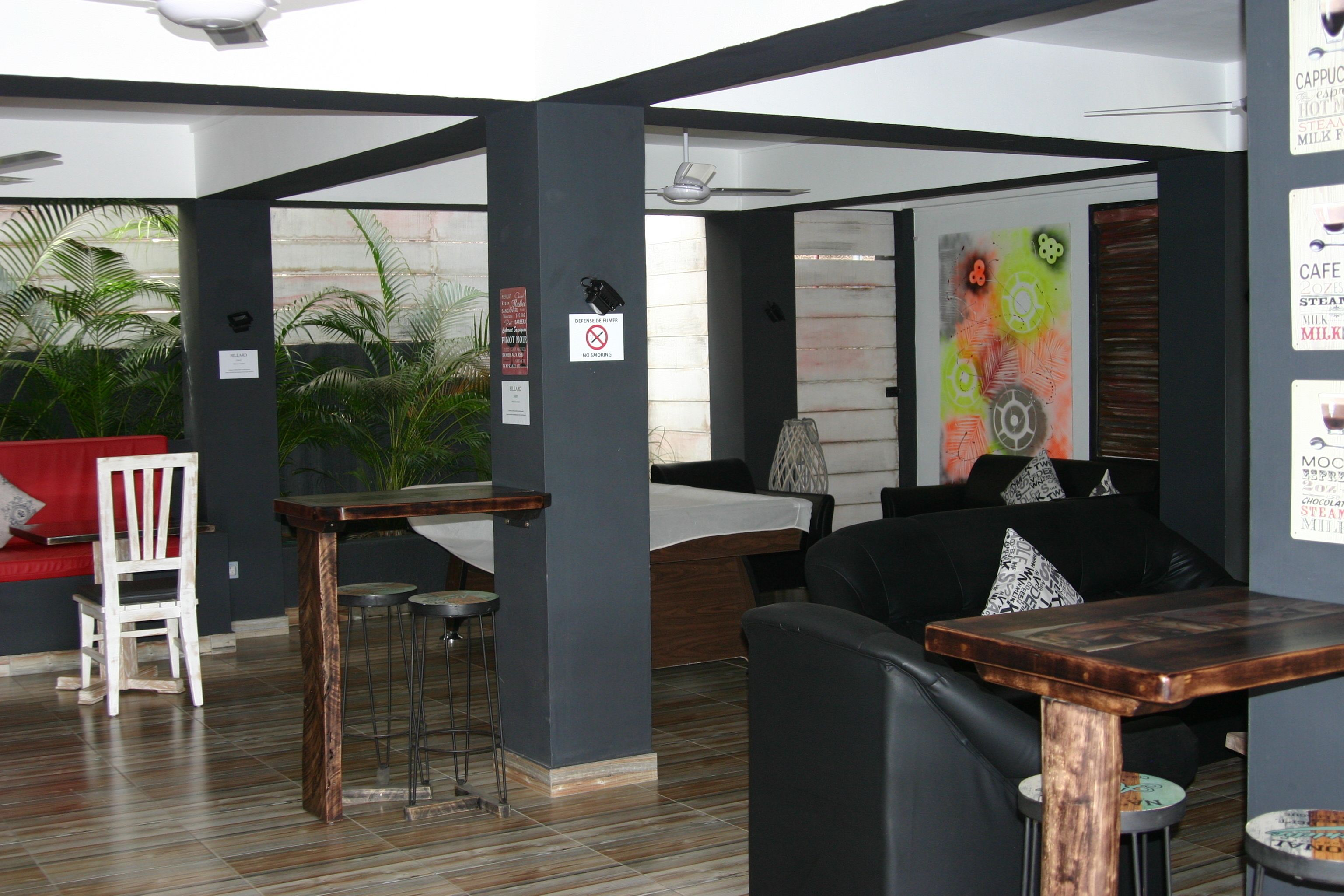 Un interior moderno con barra, asientos y una pared decorativa.