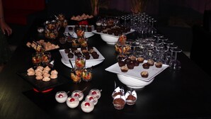 A table with various desserts and drinks, including cupcakes, fruit cups, and wine glasses. - Le Pôle Résidence (Grand-Baie)