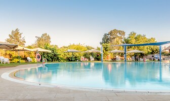 Una piscina al aire libre de temporada, sillones reclinables de piscina