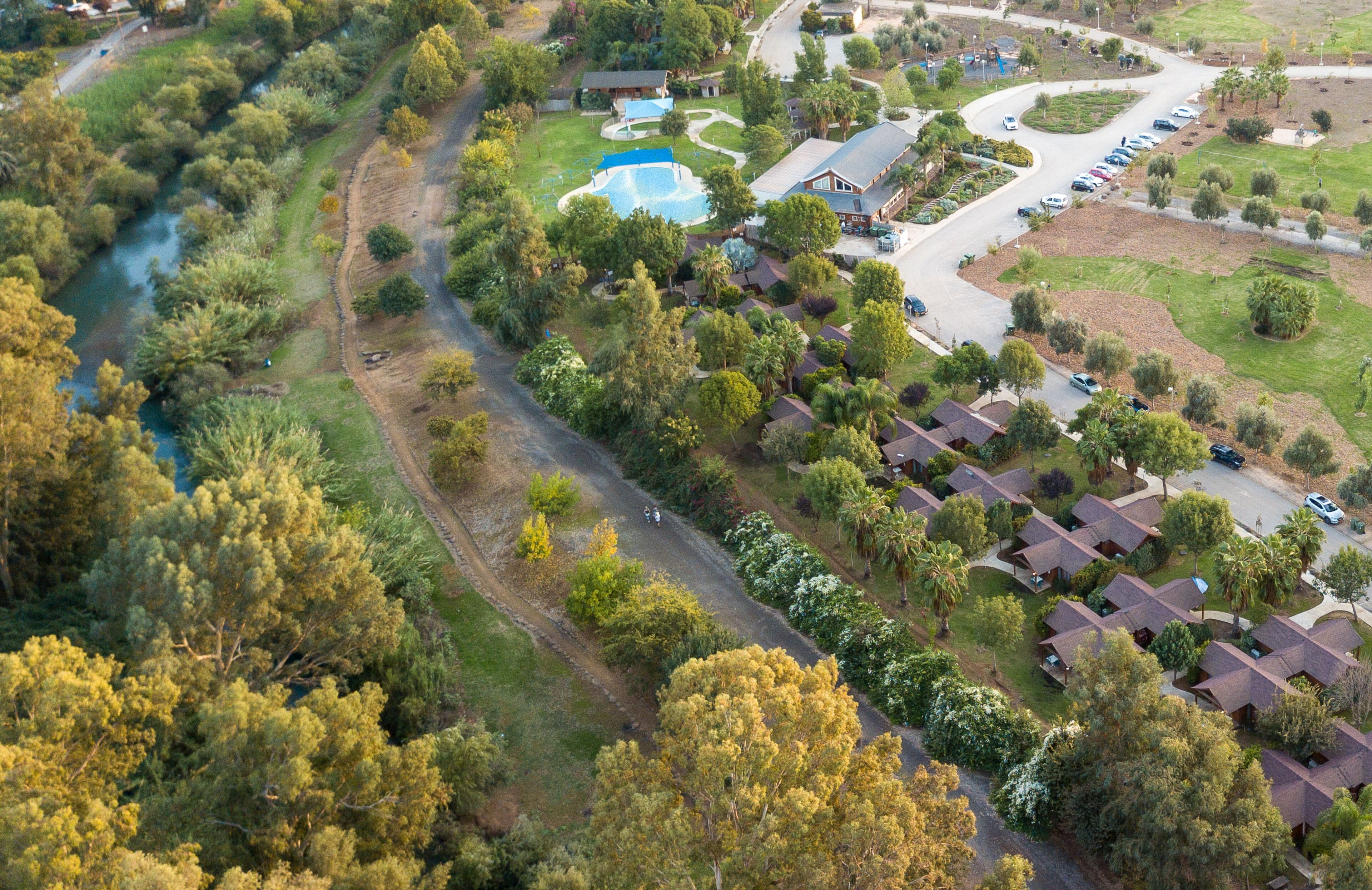 Una vista aerea di una zona residenziale con case, una piscina e una strada tortuosa.