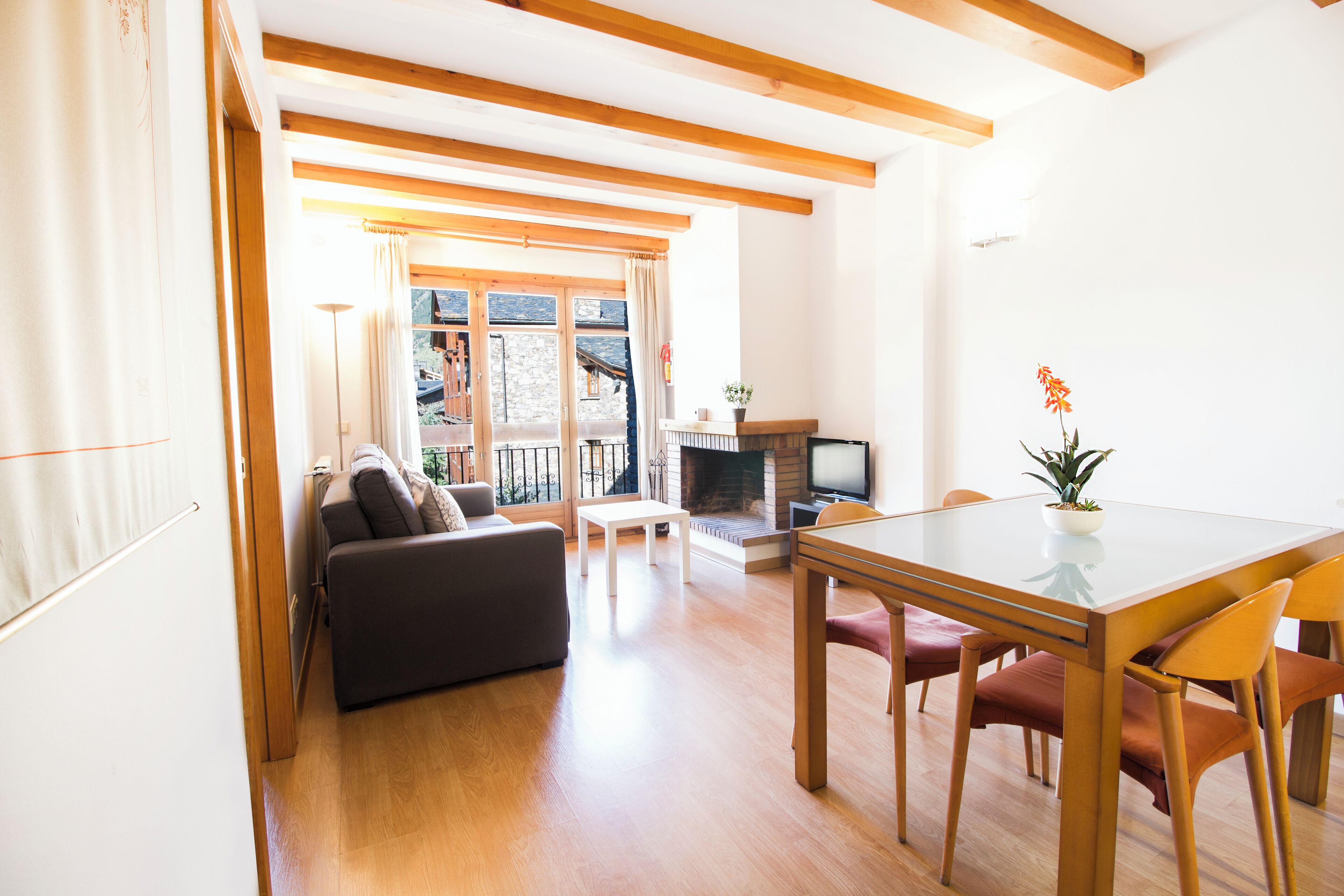 Una sala de estar moderna con un sofá, una mesa de comedor y una chimenea.