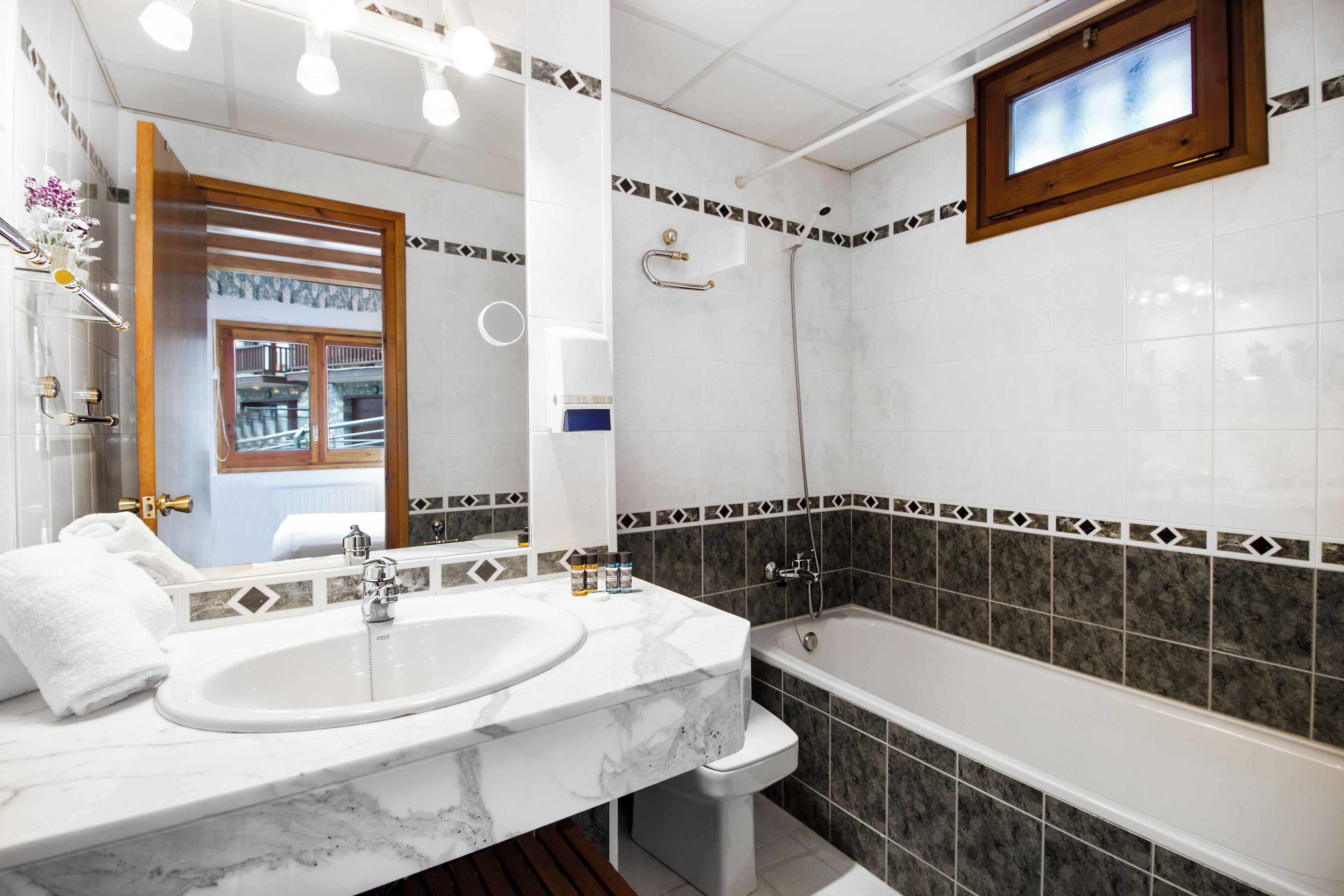 A bathroom with a marble sink, a bathtub, and a shower.