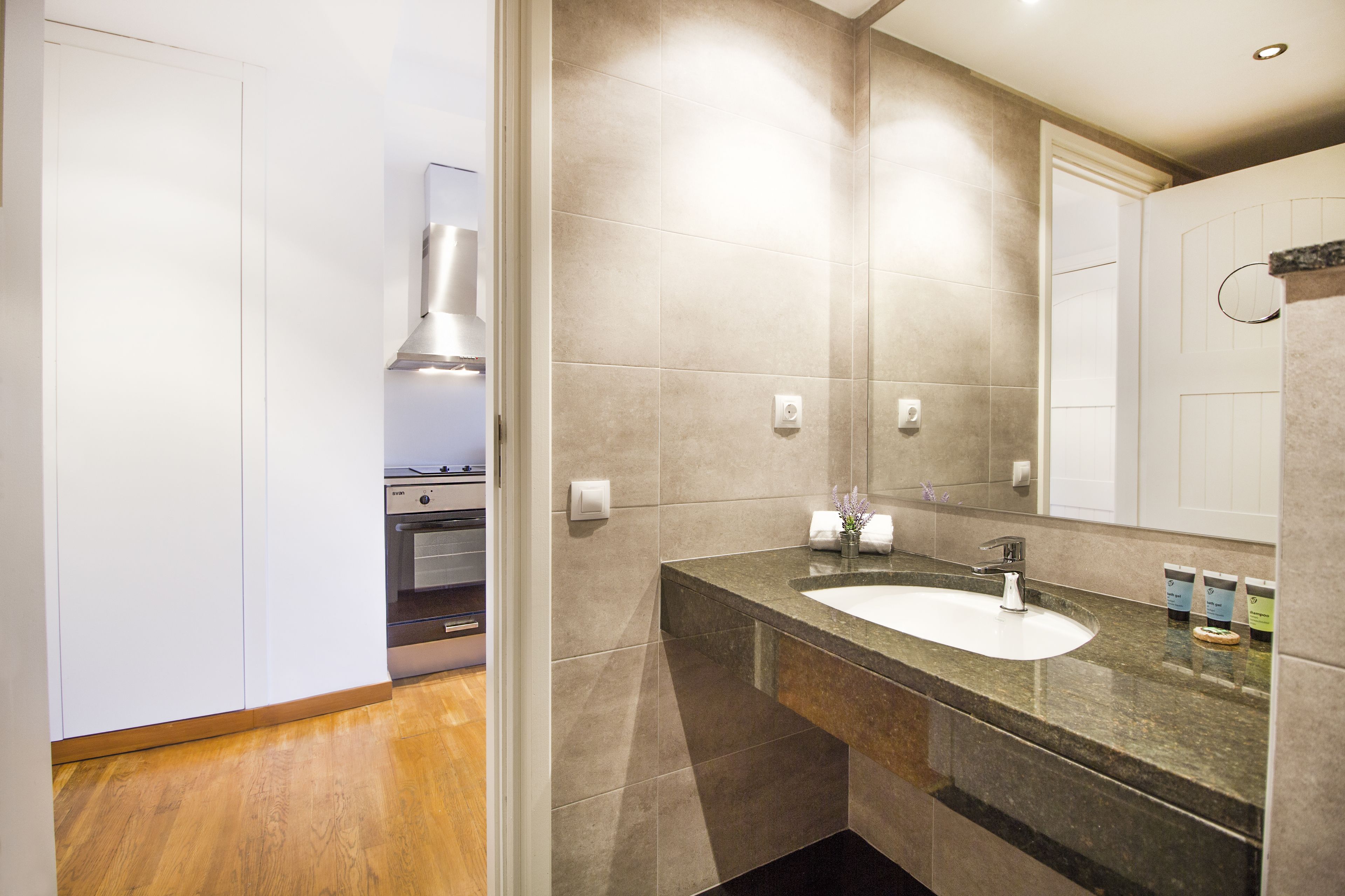 Een moderne badkamer met een grote spiegel, een wastafel en een douche.