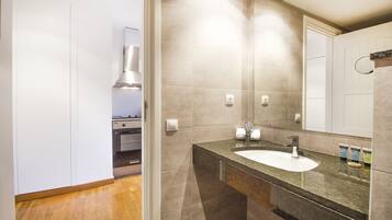 Een moderne badkamer met een grote spiegel, een wastafel en een douche.
