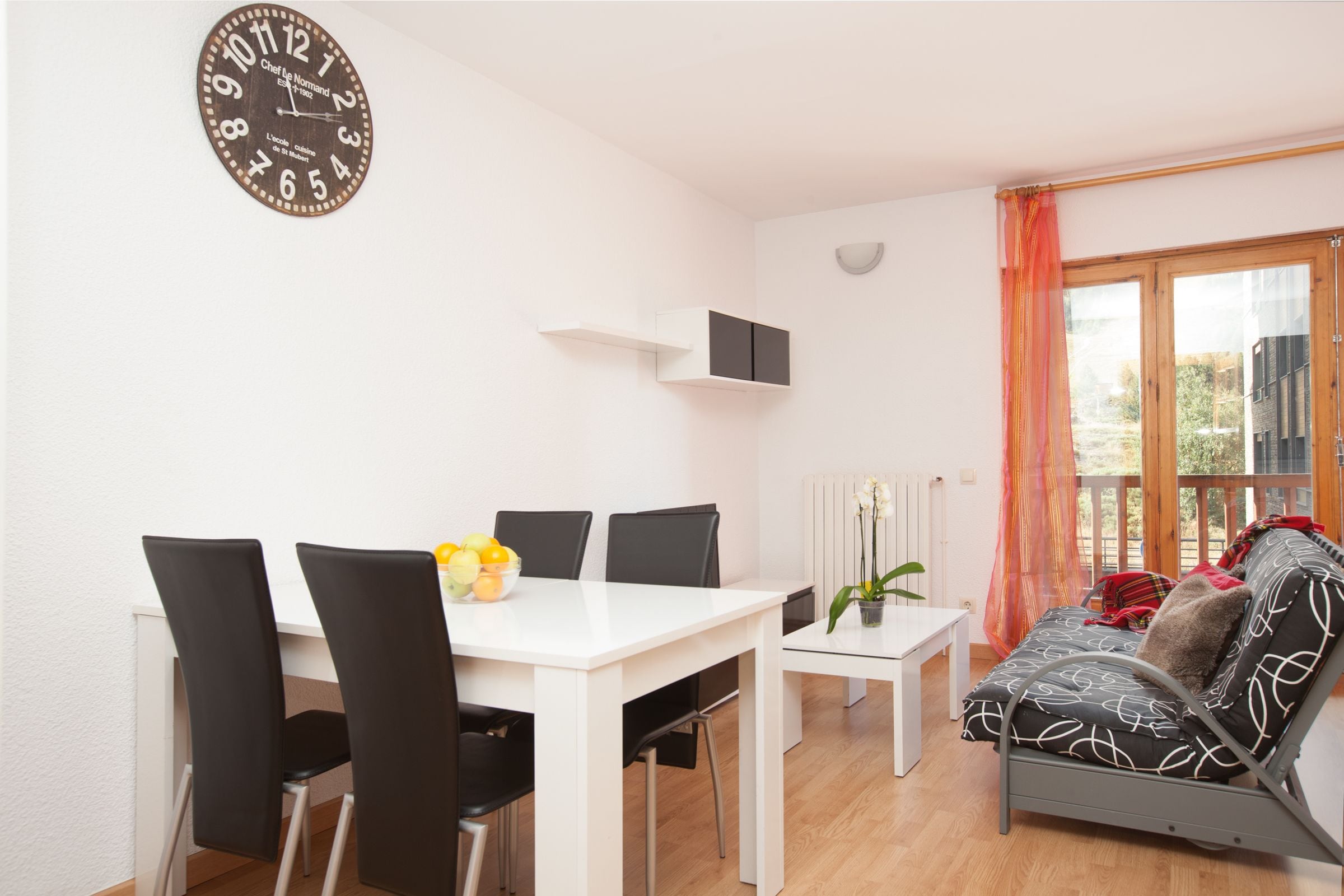 Una sala de estar moderna con comedor, un sofá y un reloj en la pared.