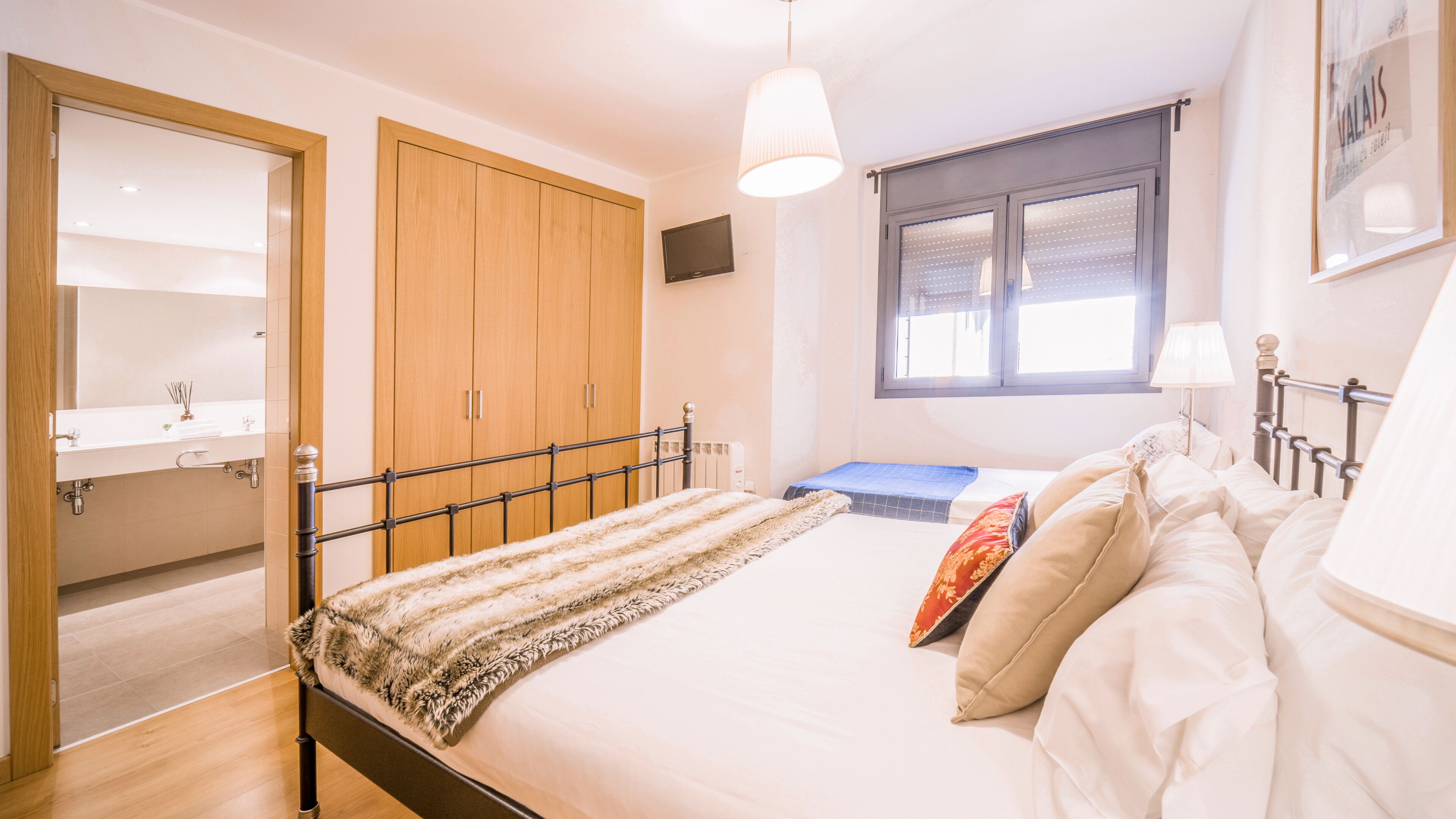 Un dormitorio con cama, ventana, armario y baño.