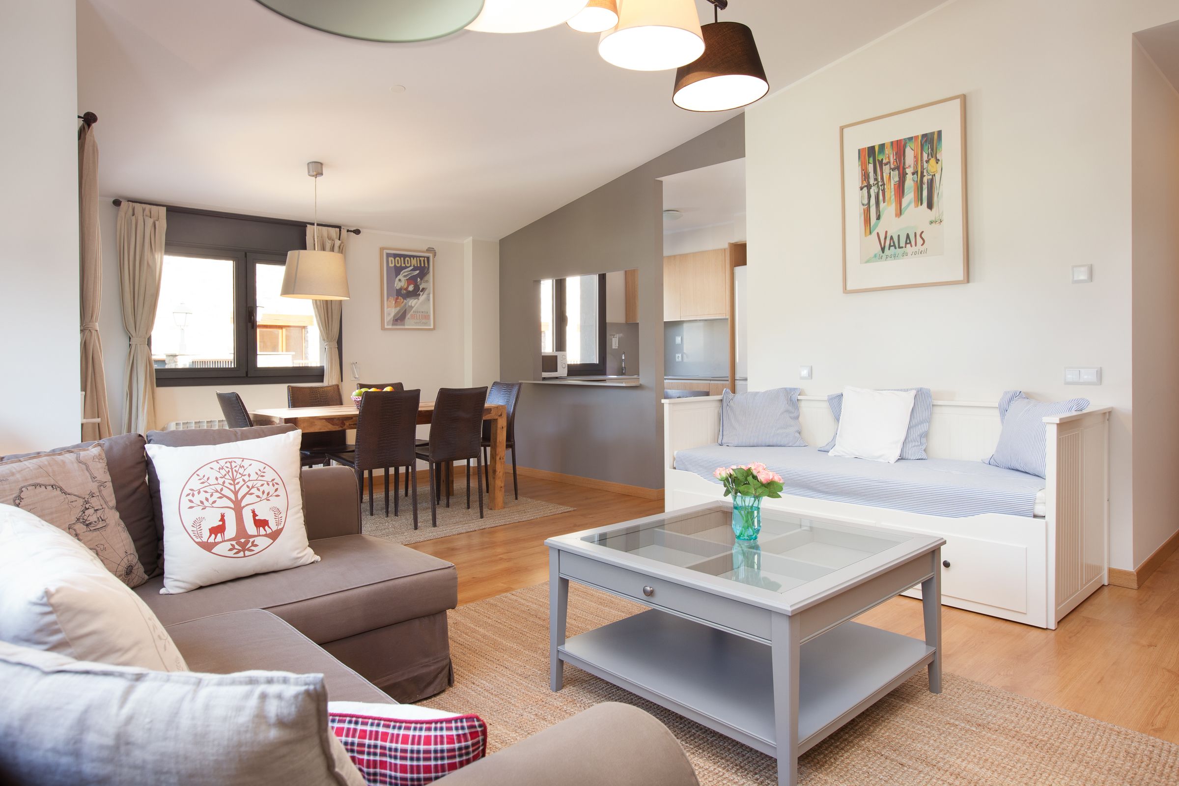 A modern living room with a sofa, coffee table, and dining area.