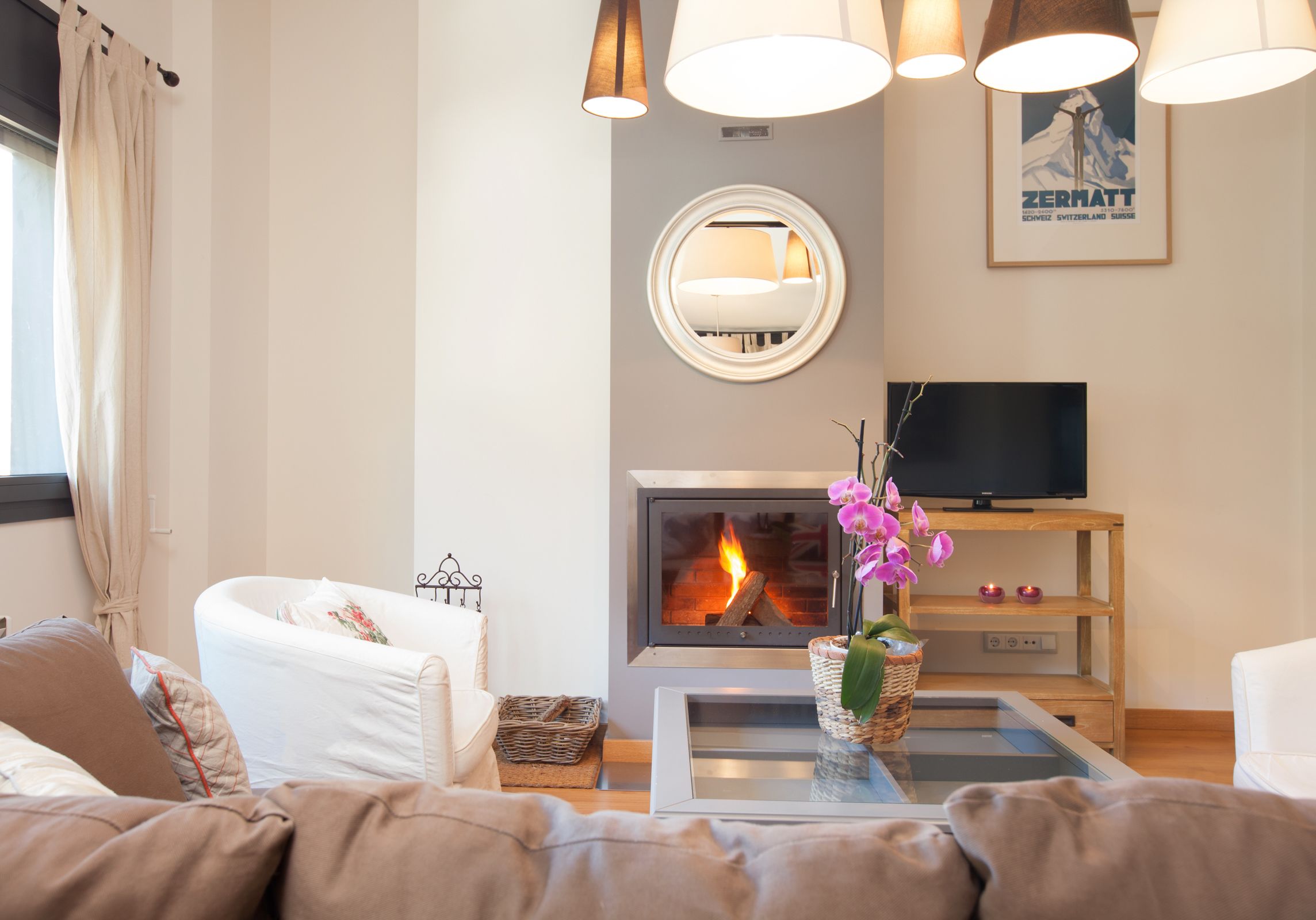 A modern living room with a fireplace, a television, and comfortable seating.